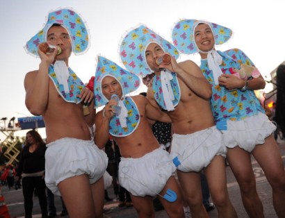 Men dressed as babies parade along Santa